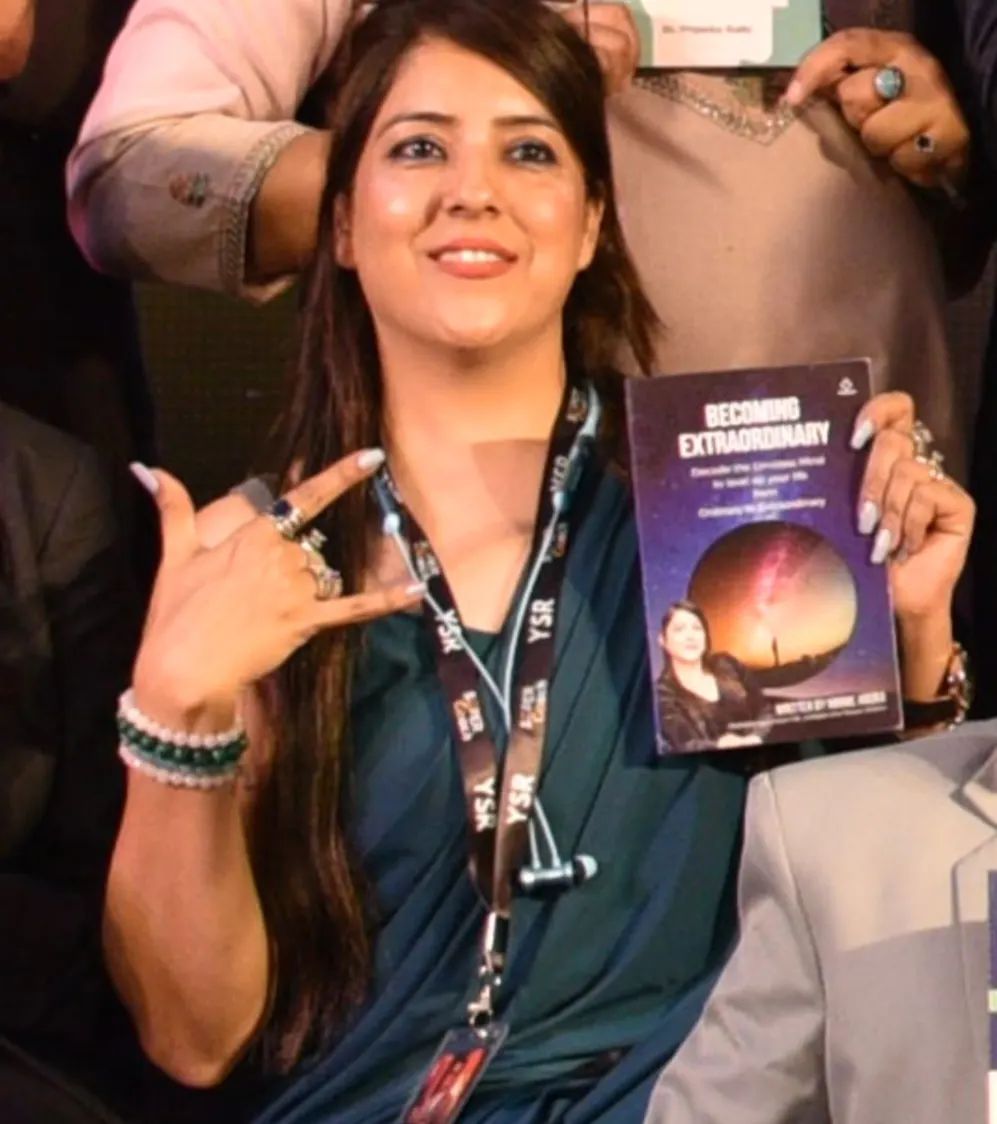 Minnie P Arora holding her book Becoming Extraordinary